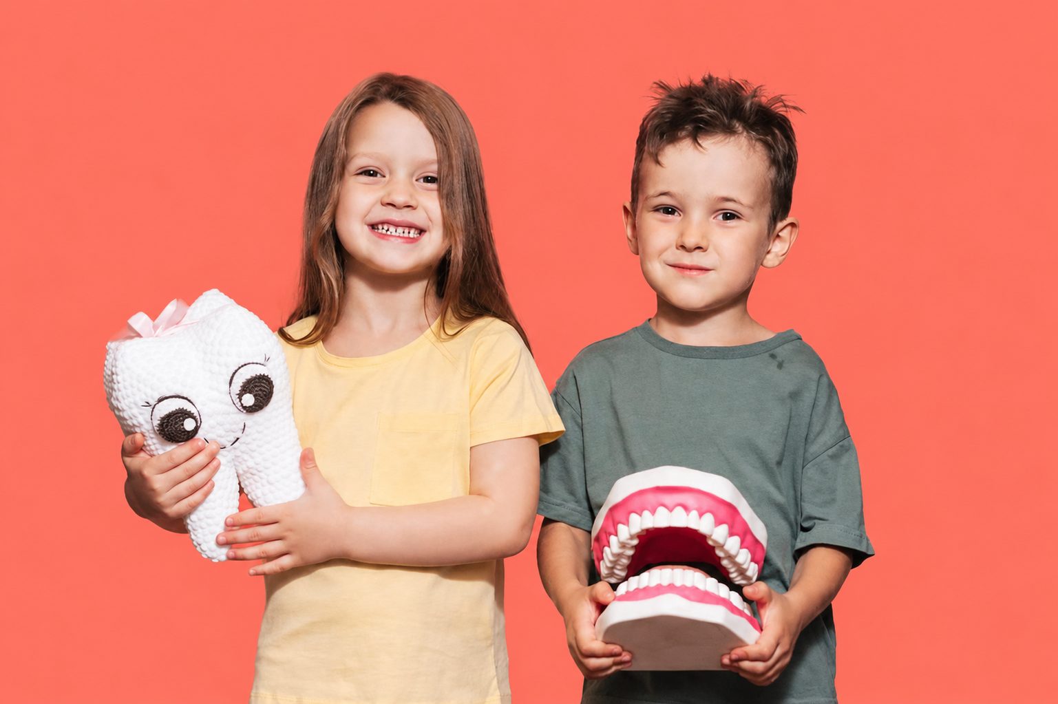 Happy kids holding a tooth plushie